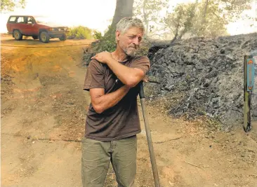  ?? DAVID ROYAL/MONTEREY HERALD ?? Theo Maehr pauses while extinguish­ing hot spots near his home in Palo Colorado Canyon on the northern Big Sur Coast. The Monterey County fire had burned 20 homes as of Monday evening, officials reported.