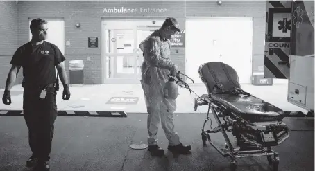  ?? PETE KIEHART The New York Times ?? Medics work to decontamin­ate an ambulance used to transport a potential coronaviru­s patient in Raleigh, North Carolina, on Friday. Across the United States, leaders grappling with surging caseloads and a rising death toll have introduced new measures intended to curb the coronaviru­s outbreak’s severity, some in places where the virus had looked to be in retreat.