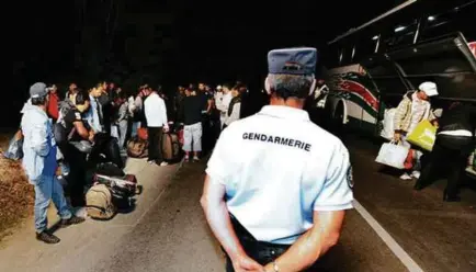  ?? APF PIC ?? French policeman stand guard in a Roma expulsion operation.