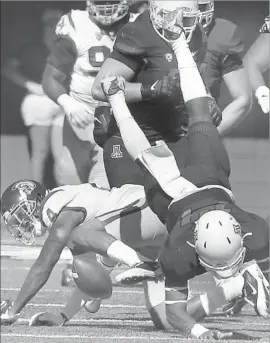  ?? Rick Scuteri Associated Press ?? USC DEFENSIVE BACK Chris Hawkins (4) upends Arizona quarterbac­k Kahlil Tate, causing a fumble that Trojans’ Adoree’ Jackson recovered in second quarter.