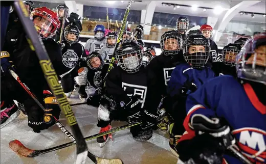  ?? GARY CORONADO/LOS ANGELES TIMES/TNS ?? Players with the Mexico City Jr. Kings youth hockey league gather after practice at the ice skating rink in Centro Santa Fe shopping mall last month in Mexico City. The league is organized and supported by the Los Angeles Kings in an effort to grow the game in Mexico, an untapped market.