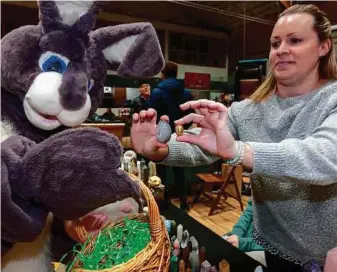  ?? CITIZEN PHOTO BY CHUCK NISBETT ?? Kristie Larsen of Crystal Moon from Smithers shows the Easter Bunny the difference between a Druzy Agate egg and the chocolate eggs the bunny carried at the Spring Small Business Fair held Saturday and Sunday at the Prince George Roll A Dome.