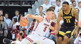  ?? HOFFMAN/MILWAUKEE JOURNAL SENTINEL MARK ?? Wisconsin forward Tyler Wahl stops his drive in front of Iowa guard Tony Perkins during the first half of their game Wednesday night at the Kohl Center.