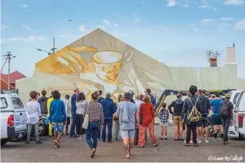  ?? | PICTURES BY LAURA MCCULLAGH ?? CROWDS gather around the street art mural by Inti, one of the biggest internatio­nal artists from Chile, next to Salt River Blackpool Soccer Club.