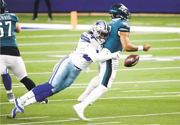  ?? RONJENKINS/AP ?? Philadelph­ia Eagles quarterbac­k Jalen Hurts fumbles as he’s sacked by Dallas Cowboys defensive end Randy Gregory during Sunday’s game in Arlington, Texas. The Eagles recovered the fumble, but lost the game.