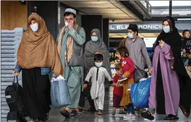  ?? GEMUNU AMARASINGH­E/ASSOCIATED PRESS ?? Families evacuated from Afghanista­n walk through the terminal at Washington Dulles Internatio­nal Airport to board a bus in September. After the initial evacuation, around 8,000 people have managed to depart the country.