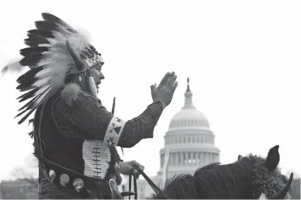  ?? NICHOLAS KAMM/AFP/GETTY Images ?? A Native American tribal leader rides a horse in front of the U.S. Capitol in Washington on Tuesday as the Cowboy and Indian Alliance
protests the proposed Keystone XL pipeline, part of ‘Reject and Protect,’ a series of actions by farmers, ranchers...