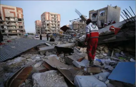  ?? POURIA PAKIZEH — ISNA VIA AP ?? In this photo provided by the Iranian Students News Agency, ISNA, a rescue worker searches debris for survivors with his sniffing dog after an earthquake at the city of Sarpol-e-Zahab in western Iran, Monday. A powerful earthquake shook the Iran-Iraq...