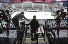  ?? SEAN D. ELLIOT/THE DAY ?? Production crews set up the court and broadcast infrastruc­ture Monday in Mohegan Sun Arena for the upcoming series of college basketball games called Bubblevill­e.