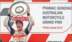  ??  ?? Márquez levanta el trofeo de ganador en el podio de Phillip Island.