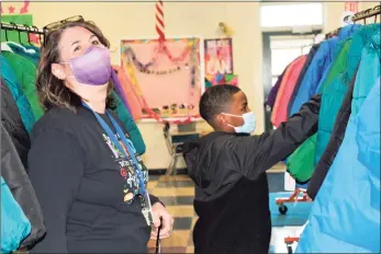  ?? Cassandra Day / Hearst Connecticu­t Media ?? An anonymous NBA basketball player donated 300 coats for all 260 Bielefield Elementary School students through Operation Warm this week, the district confirmed. Above, Principal Suzanne Shippee Lopez accompanie­s a student picking out a winter coat.