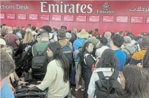  ?? ?? People queue at a flight connection desk after a rainstorm hit Dubai, causing delays at the Dubai Internatio­nal Airport.