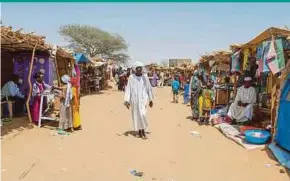  ?? AFP PIC ?? A man walking at a market at the Adre refugee camp in Chad recently. Chad is home to the largest number of Sudanese refugees, nearly a million.