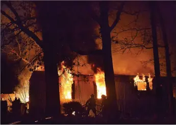  ?? TIMES photograph by Annette Beard ?? Volunteer firefighte­rs from four agencies battled the blaze that destroyed the home of Mitchel Johnson and his family about 6 p.m. Saturday, Feb. 15.