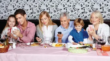  ?? DREAMSTIME ?? Instead of keeping phones on the table, suggest a “check phone break” halfway through dinner, Karen Cleveland writes.