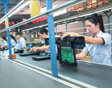  ?? XINHUA ?? Quality-control inspectors at work at TCL’s factory in Vietnam. One of the earliest Chinese enterprise­s to expand overseas, TCL entered Vietnam in 1999. Its market share in the Southeast Asian country has exceeded 16 percent by 2015.