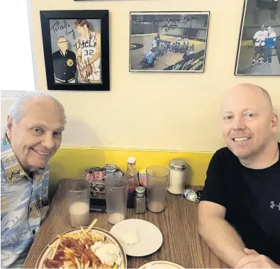  ?? UCLA ?? Hep Cronin, left, sits with his son and UCLA coach Mick Cronin in the booth where legendary coach John Wooden used to have breakfast.