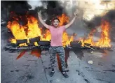  ?? AFP ?? A Lebanese man gestures in front of burning tires during a recent protest in Beirut against dire living conditions amidst the ongoing economic and political crisis.