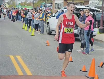  ?? NIKKI SULLIVAN/CAPE BRETON POST ?? Runner James Murphy pushes hard to cross the finish line first for this year’s Cabot Trail Relay Race. Close behind him is Nick Croker from Toronto.