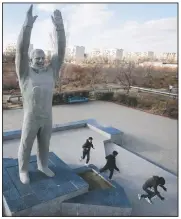  ?? (AP/Dmitri Lovetsky) ?? Children play near a sculpture of Gagarin at the Russian-leased Baikonur cosmodrome — the world’s first and largest operationa­l space launch facility — in Baikonur, Kazakhstan.