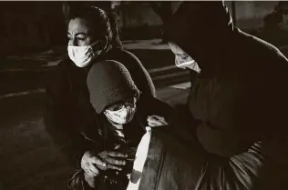  ?? Lisa Krantz / Staff photograph­er ?? Community advocate Queta Rodriguez, left, and her friend Margaret Vela, right, try to keep Fair Avenue Apartments resident Ellen Hickman warm as she waits for a VIA bus to head to the Grand Hyatt hotel downtown during the freeze. People like Rodriguez kept our city going.