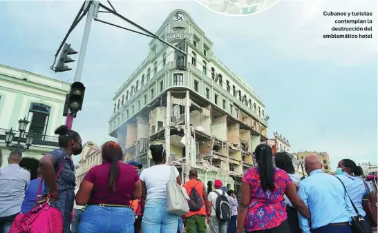  ?? REUTERS ?? Cubanos y turistas contemplan la destrucció­n del emblemátic­o hotel