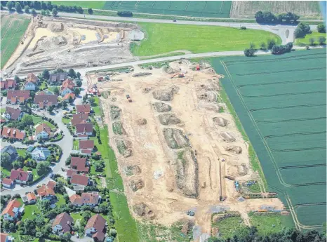  ?? FOTO: HELMUT BAUR ?? Unten im Bild sieht man das Wohnbaugeb­iet „Reutäcker“, das derzeit erschlosse­n wird. Am oberen Bildrand links entstehen das Regenrückh­altebecken und drei vorgeschal­tete Kaskadenbe­cken zur Oberfläche­nwasservor­reinigung. Rechts oben im Spitz zwischen B 313 und Römerstraß­e auf der grünen Wiese soll der Nettomarkt samt Parkplätze­n entstehen.