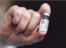  ?? Jessica Hill / Associated Press file photo ?? Johnson & Johnson COVID-19 vaccine is held by pharmacist Madeline Acquilano at Hartford Hospital in Hartford.