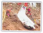  ?? ?? Rescue teams with a piece of fuselage.