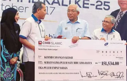  ?? PIC BY SHARUL HAFIZ ZAM ?? Education Minister Datuk Seri Mahdzir Khalid (second from right) presenting a mock cheque to state West Malaysia Malay Teachers Union chairman Jasni Md Kechik (second from left) in Alor Star yesterday.
