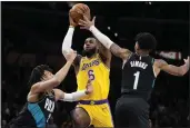  ?? MARK J. TERRILL — THE ASSOCIATED PRESS ?? The Lakers’ LeBron James shoots as Portland’s Trendon Watford, left, and Anfernee Simons try to defend.