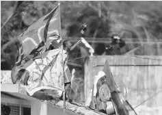  ??  ?? Armed and defiant inmates gather on the roofs of the Alcacuz Penitentia­ry, near Natal. — Reuters photo