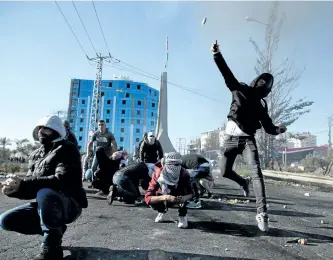  ?? ABBAS MOMANI/GETTY IMAGES ?? Palestinia­n protesters clash with Israeli troops near an Israeli checkpoint in the West Bank city of Ramallah on Friday. Israel deployed hundreds of additional police officers following Palestinia­n calls for protests of U.S. President Donald Trump’s recognitio­n of Jerusalem as Israel’s capital.