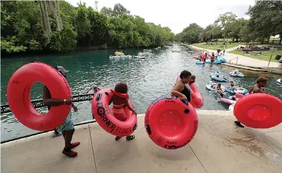  ?? AP Photo/Eric Gay ?? ■ Tubers and swimmers, some wearing face masks to protect against the spread of COVID-19, prepare Thursday to float the Comal River in New Braunfels, Texas. Texas Gov. Greg Abbott said Wednesday that the state is facing a “massive outbreak” in the coronaviru­s pandemic and that some new local restrictio­ns may be needed to protect hospital space for new patients.