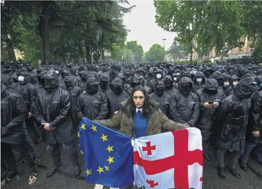  ?? PHOTOGRAPH­S: GIORGI ARJEVANIDZ­E/GETTY; ZURAB TSERTSVADZ­E/ GETTY; AP ?? ▲ Thousands of people faced black-clad police, left, in Tbilisi to protest against the controvers­ial ‘foreign agents’ bill passed by Georgia’s parliament of yesterday. Violence spread into the chamber as MPs began the third and final reading, below