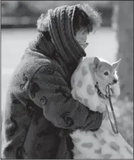  ??  ?? Cuddled up: Doc Cheng bundles up with her chihuahua Happy as she braves a cold Arctic blast that brought temperatur­es down to 6 degrees above zero, closing local schools and shattering cold weather records, on Tuesday in Atlanta.