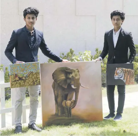  ?? Reem Mohammed / The National ?? Rohan and Rahu Raju with some of the paintings that have brought them internatio­nal attention. Sheikh Nahyan bin Mubarak, Minister for Culture, Youth, and Social Developmen­t, recently bought some of their work