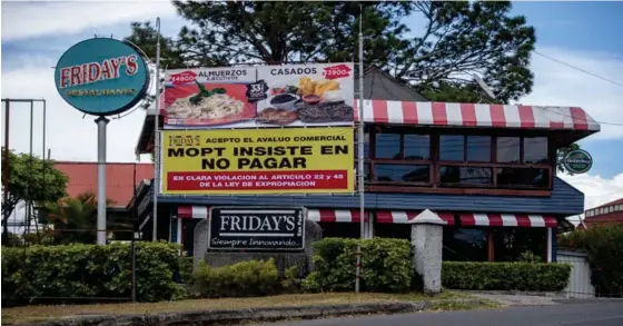  ?? JOSÉ CORDERO ?? Carlos Felipe Huezo, dueño del restaurant­e Friday’s, en Montes de Oca, donde se construirá un paso a desnivel, denunció en una manta frente al local que él aceptó el avalúo pero desde octubre está “pegado” en la oficina del ministro Méndez Mata.