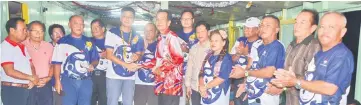  ??  ?? Andrew Wong (sixth left) hands over a contributi­on to a recipient. Also seen are Andrew Shilling (fourth left), Tuai Rumah Juing (seventh left), Andrew Ting (ninth left) and others.