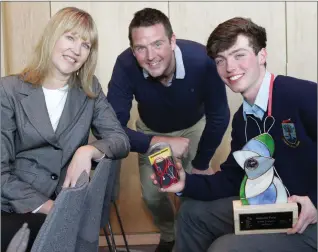  ??  ?? Luke Byrne, senior award winner at the Student Enterprise Awards National Final, showing off his ‘Headphone Helpers’ to Sheelagh Daly, Head of Enterprise at LEO Wicklow, and Ruairi Farrell, Year Head and Business Department Coordinato­r at Colaiste...
