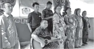  ??  ?? PERSEMBAHA­N nyanyian koir guru-guru SK Basai Baru pimpinan Thomas (pemain gitar) bersama Tsau (kiri).