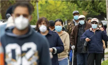  ?? Photograph: Mary Altaffer/AP ?? Residents of Kew Gardens Hills in Queens, New York City, queue to pick up free face masks.