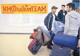  ??  ?? Cesar Mares, 16, left, and Antonio Serna, 16, both of Santa Fe, prepare to board a bus with around 200 other immigrants and immigrant activists from around the state who are traveling to Washington, D.C.