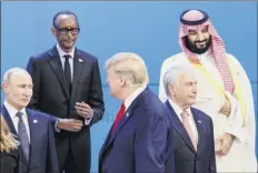  ?? Tom Brenner / The New York Times ?? President Donald Trump, center, walks past President Vladimir Putin of Russia, left, and Crown Prince Mohammed bin Salman of Saudi Arabia, right, while lining up with world leaders for a group photo at the G-20 summit, at the Interconti­nental hotel in Buenos Aires on Friday.