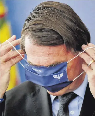  ?? Ueslei Marcelino / Reuters ?? Jair Bolsonaro es treu la mascareta, la setmana passada a Brasília.