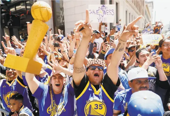 ?? Scott Strazzante / The Chronicle ?? Among the countless faces in the blue-and-gold crowd at Golden State’s victory parade, Leo Froma and Andrea Narvasa of San Jose cheer Klay Thompson.
