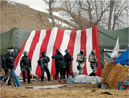  ?? PHOTO: REUTERS ?? Law enforcemen­t officers move in to clear the main Dakota Access oil pipeline protest camp near Cannon Ball, North Dakota.
