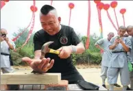  ?? XU JUNWEN / FOR CHINA DAILY ?? Cao Tingyou, headmaster of a school of the martial art or Iron Palm, shows how his hand can be used to drive nails into a board. The demonstrat­ion was part of the first Great Meeting Open to All, held at the Shaolin Temple in Songshan, Henan province,...