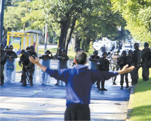  ??  ?? Un homme confronte la Garde nationale vénézuélie­nne qui protège la base militaire de Paramacay, le 8 août. − Associated Press: Juan Carlos Hernandez