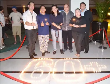  ??  ?? Chong (third right) and his team pose for the camera after the Earth Hour’s light switch-off at the hotel.